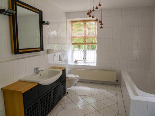 ein Badezimmer mit einem Waschbecken, einem WC und einer Badewanne in der Unterkunft Gutshaus Jülchendorf in Jülchendorf