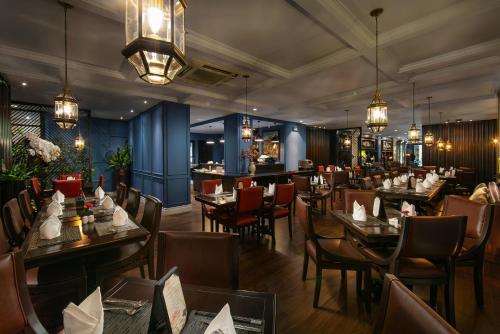 een restaurant met tafels en stoelen in een kamer bij O'Gallery Premier Hotel & Spa in Hanoi