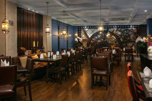 een restaurant met tafels en stoelen in een kamer bij O'Gallery Premier Hotel & Spa in Hanoi