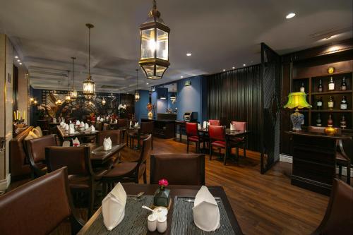 een restaurant met tafels en stoelen en een bar bij O'Gallery Premier Hotel & Spa in Hanoi