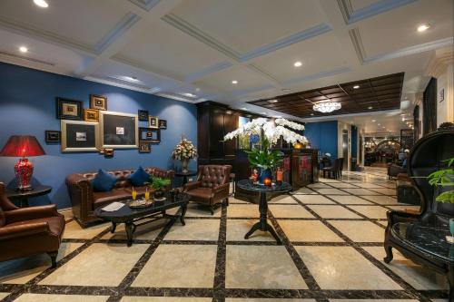 ハノイにあるオーギャラリー プレミア ホテル＆スパの青い壁と革張りの家具が備わるロビー