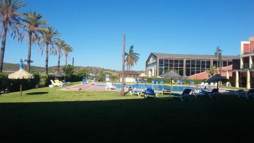 um resort com piscina, palmeiras e um edifício em One bedroom appartement with sea view private pool and enclosed garden at Estombar 2 km away from the beach em Estômbar