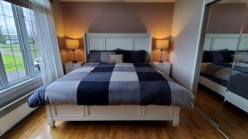 um quarto com uma cama, 2 candeeiros e um espelho em Waterfront Oasis Luxury Retreat Between Ottawa and Montreal em Hawkesbury