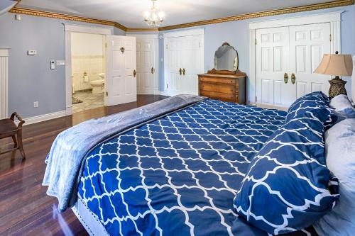 a bedroom with a bed with a blue and white comforter at Mulgrave Mansion in Mulgrave