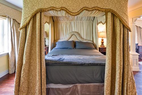 a bedroom with a canopy bed with curtains at Mulgrave Mansion in Mulgrave