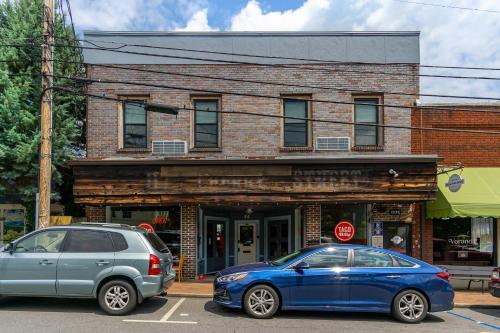two cars parked in front of a brick building at Cherry Street Loft (A) Pet-Friendly & In the Heart of Downtown Black Mtn! in Black Mountain