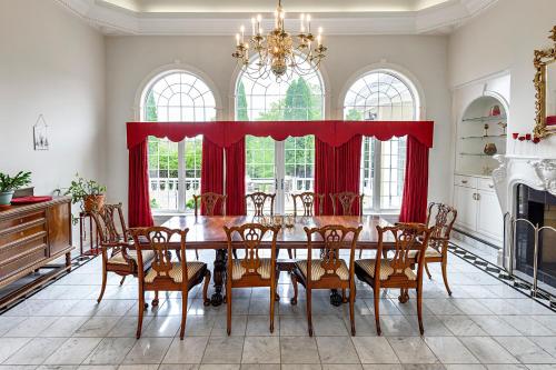 a dining room with a table and red curtains at Mulgrave Mansion in Mulgrave