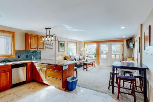 a kitchen and living room with a table and a couch at Driftin' Cabanas in Chelan