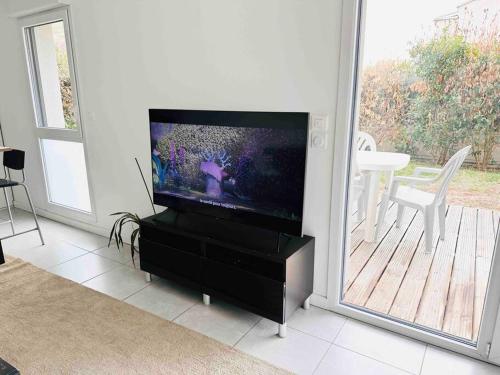 Μια τηλεόραση ή/και κέντρο ψυχαγωγίας στο La Roseraie Toulousaine avec parking privé