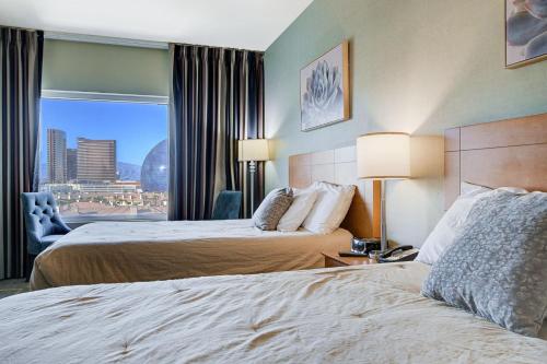 a hotel room with two beds and a window at Modern Oasis Steps Away from the Las Vegas Strip in Las Vegas