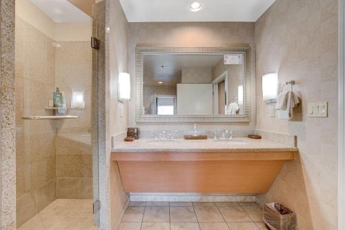 a bathroom with a sink and a mirror and a shower at Modern Oasis Steps Away from the Las Vegas Strip in Las Vegas