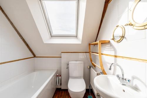 a bathroom with a toilet and a sink and a tub at Ville Daniel in Pordic
