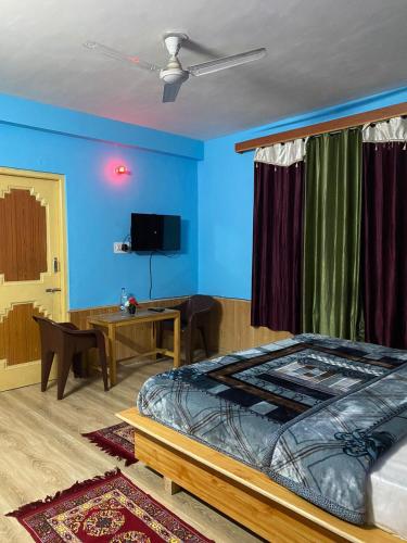 een slaapkamer met een bed en een blauwe muur bij Fresco Moonlight in Manāli