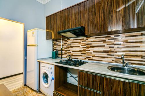 eine Küche mit einer Spüle, einem Herd und einem Kühlschrank in der Unterkunft Qız Qalası 2 room Sweet Home in Baku