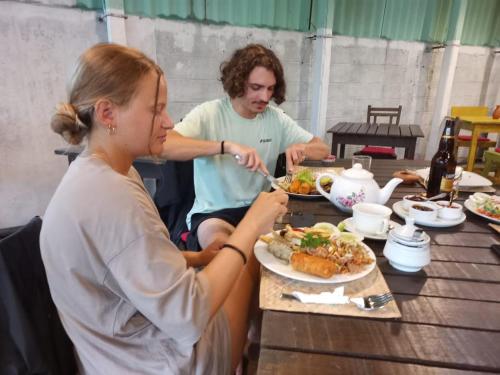 mężczyzna i kobieta siedzący przy stole jedzący jedzenie w obiekcie Seadina Coral Home w mieście Matara