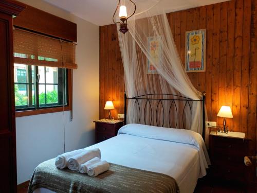 a bedroom with a bed with two towels on a bench at Casa Rural Pontevedra con piscinajardínbarbacoa in Pontevedra