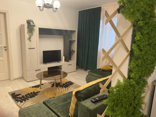 a living room with a couch and a tv at Green Apartament in Bacău