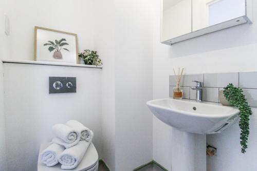 a bathroom with a sink and a toilet with towels at The Nest LE1 in Leicester