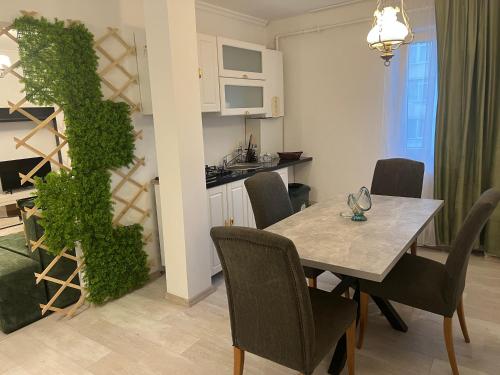 un comedor con una mesa y una planta verde en Green Apartament, en Bacău