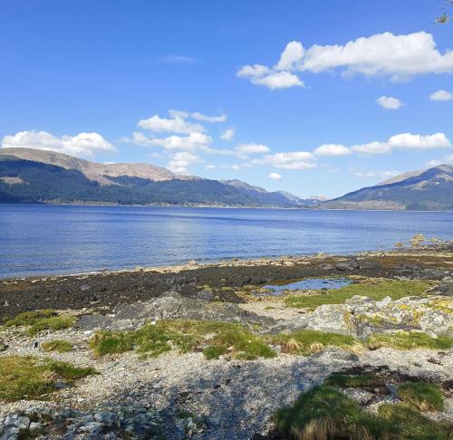 a large body of water with mountains in the background at Peaceful and Stunning Waterside Location in Helensburgh