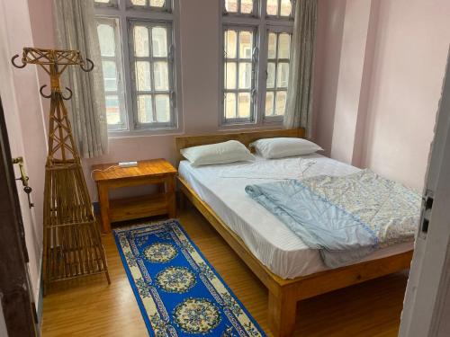 a bedroom with a bed in a room with windows at Himalayan Vacation Home in Kathmandu