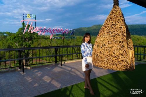 a woman standing in front of a haystack at Elevated Serenity Lodge in Khao Kho in Khao Kho