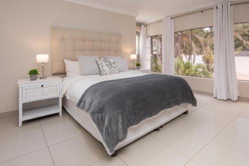 a white bedroom with a large bed and a window at The Beach Palace Ramsgate in Margate