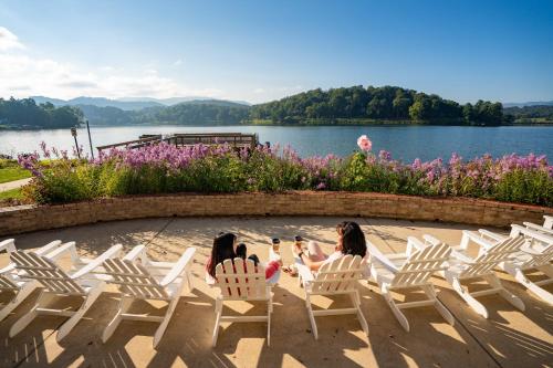 two girls sitting in chairs in front of a lake at Lakeshore Living in Lake Junaluska