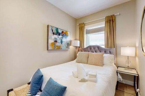 een slaapkamer met een groot wit bed met blauwe kussens bij Chic River North Retreat in Chicago