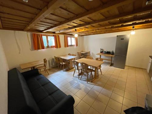 a living room with a couch and tables and a kitchen at Pension Balm in Meiringen