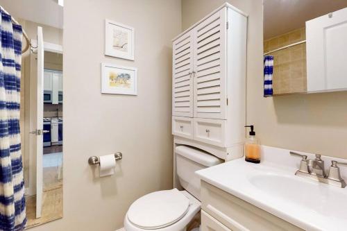 een witte badkamer met een toilet en een wastafel bij Chic River North Retreat in Chicago