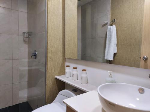 a bathroom with a shower and a sink and a toilet at San Peter Family Suites in Medellín