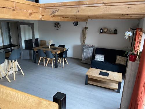 un salon avec un canapé et une table dans l'établissement Maison cosy et calme, à Saint-Symphorien