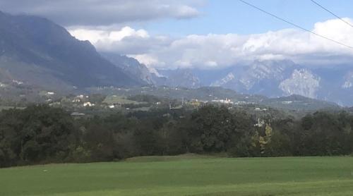a green field with mountains in the background at Il mondo roverso in Feltre