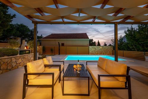 a patio with chairs and a table and a swimming pool at Dalmor holiday house in Rovanjska
