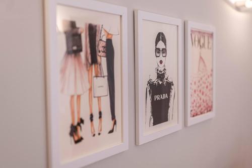 a row of pictures on a wall with clothes at Solferino34 in Milan