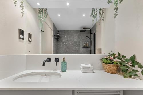 a white bathroom with a sink and a mirror at Tranquil 2 bedroom Apartment Close to St. Paul's Cathedral in London
