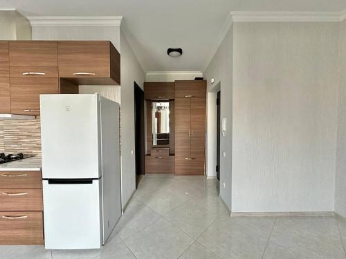 a kitchen with a white refrigerator and wooden cabinets at Graz Narek house 3 in Altenfelden