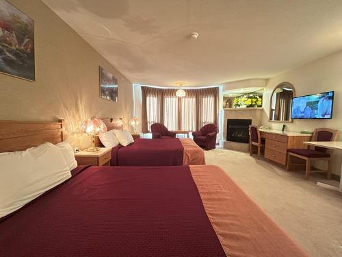 una camera d'albergo con due letti e un soggiorno di Western Budget Motel Ponoka a Ponoka