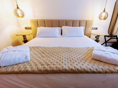 a bedroom with a large bed with two tables at INFINITVM in Sigüenza