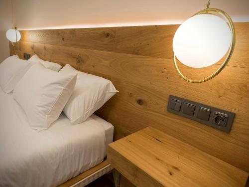 a bedroom with a bed with a lamp and a table at INFINITVM in Sigüenza