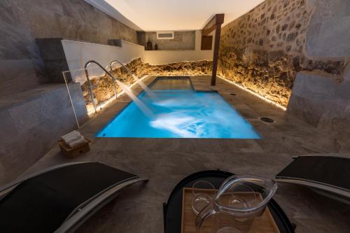 a bathroom with a plunge pool in the middle of a room at INFINITVM in Sigüenza