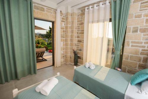 a bedroom with two beds and a view of a patio at Villa Stone Diamond in Sívas