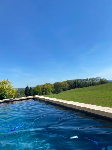 - une piscine d'eau bleue dans l'établissement Domaine de Montmery sa piscine son jardin ses espaces, à Ambazac