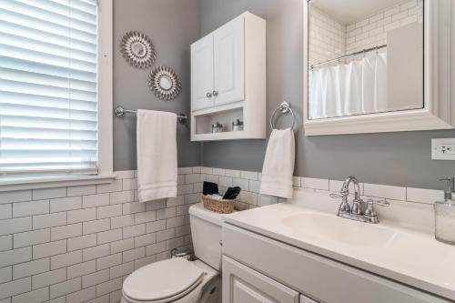 a white bathroom with a toilet and a sink at Pearly Gates l 3 Bed l Sleeps 5 l w 2-Car Garage in Forest Park