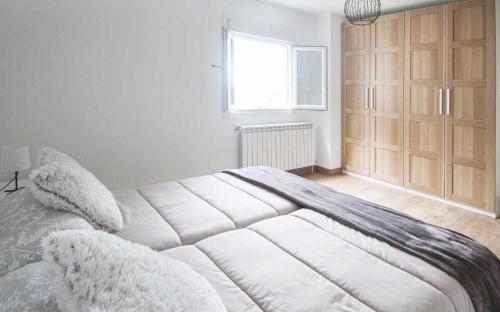 a white bed in a room with a window at AG Casa Anema 10 huéspedes a 2km de la playa Razo in A Coruña