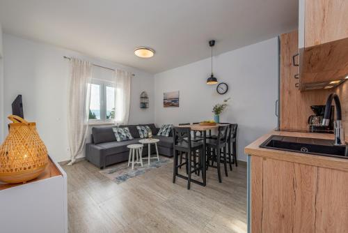 a kitchen and living room with a couch and a table at Dalmor holiday house in Rovanjska