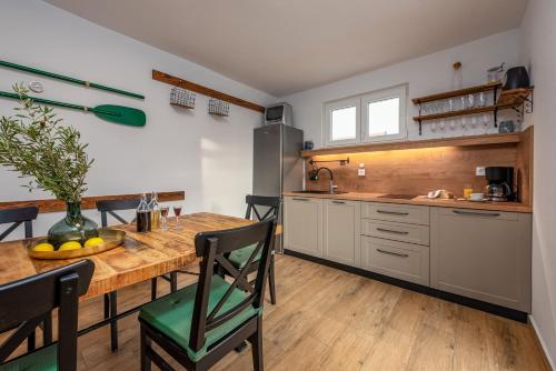 a kitchen with a wooden table and a dining room at Dalmor holiday house in Rovanjska