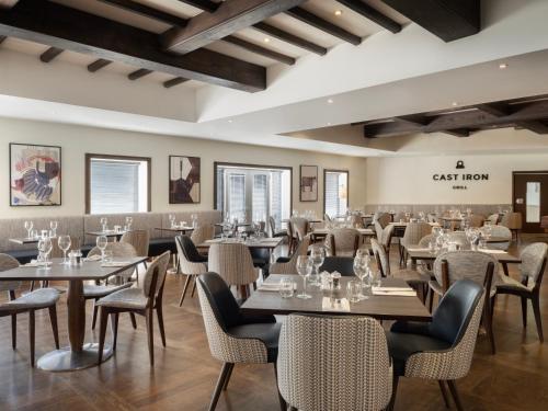 メードストンにあるDelta Hotels by Marriott Tudor Park Country Clubのテーブルと椅子が備わるレストラン