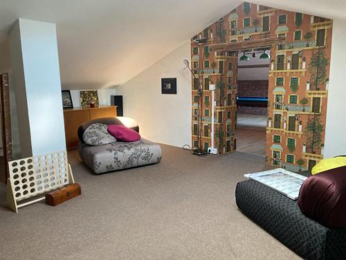 ein Wohnzimmer mit einem Sofa und einem Bett in einem Zimmer in der Unterkunft Le Clos du Verger in La Motte-du-Caire